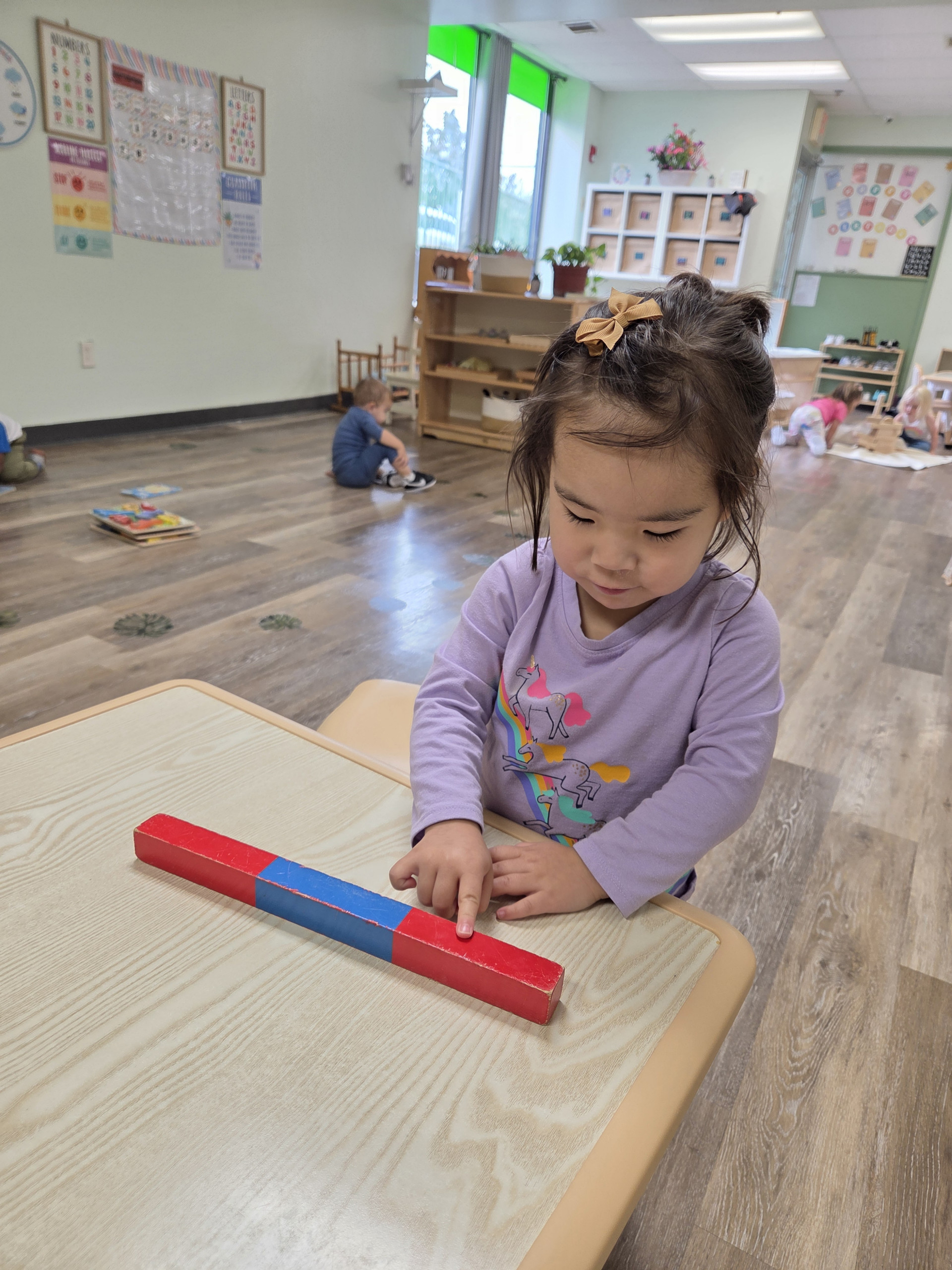 A child working with Montessori number rods
