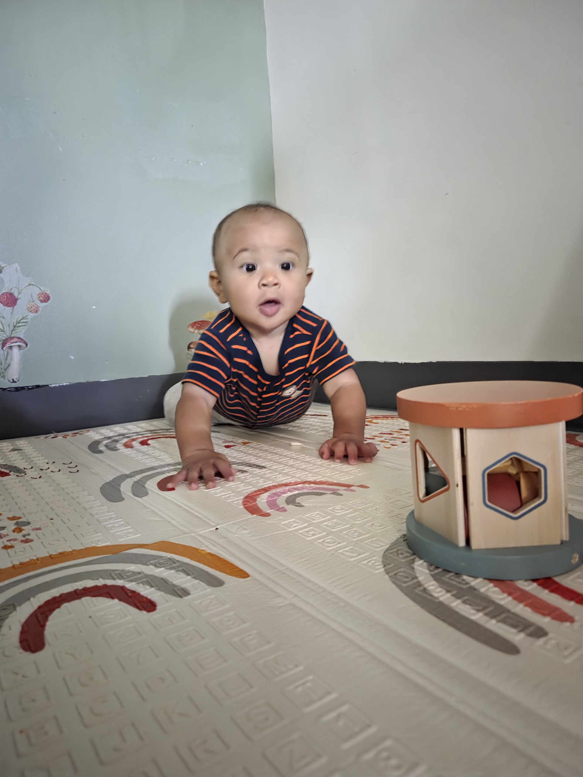 A baby exploring wooden toys in the infant classroom